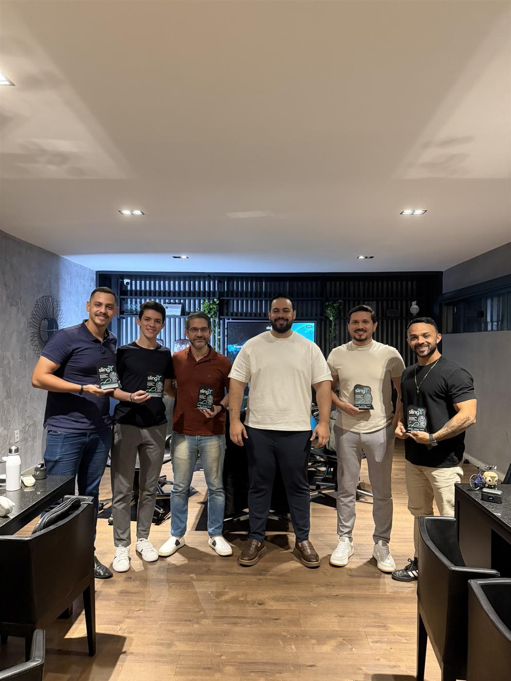 Turma reunida ao final do Núcleo, segurando as placas de vidro com o logotipo da Sling